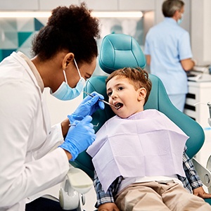 Dentist examining little boy’s mouth