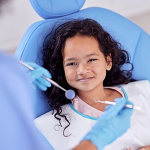 Girl in dental chair smiling about to have exam