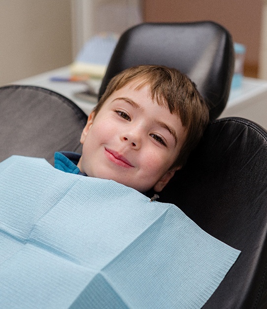 Three young kids holding dental care instruments