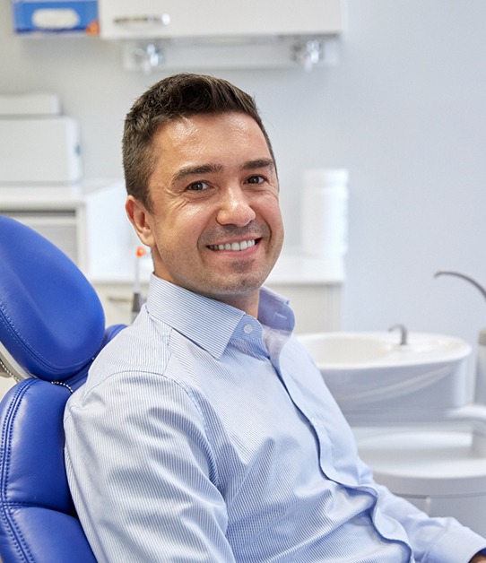 Boy in dental chair with pink laughing gas mask on nose