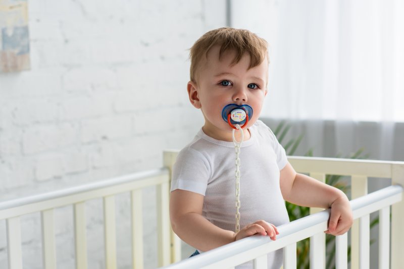 baby with a pacifier in its mouth 