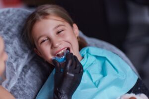 Dentist fitting child with mouthguard.