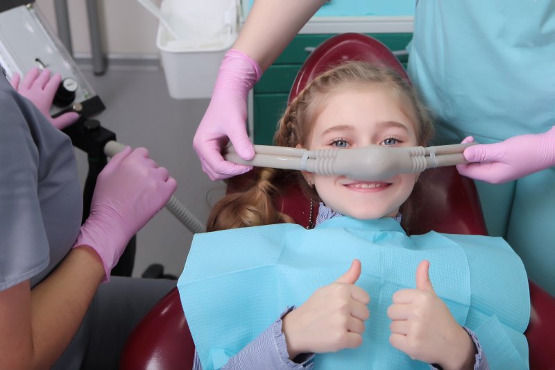 Young patient giving thumbs-up while under nitrous oxide sedation